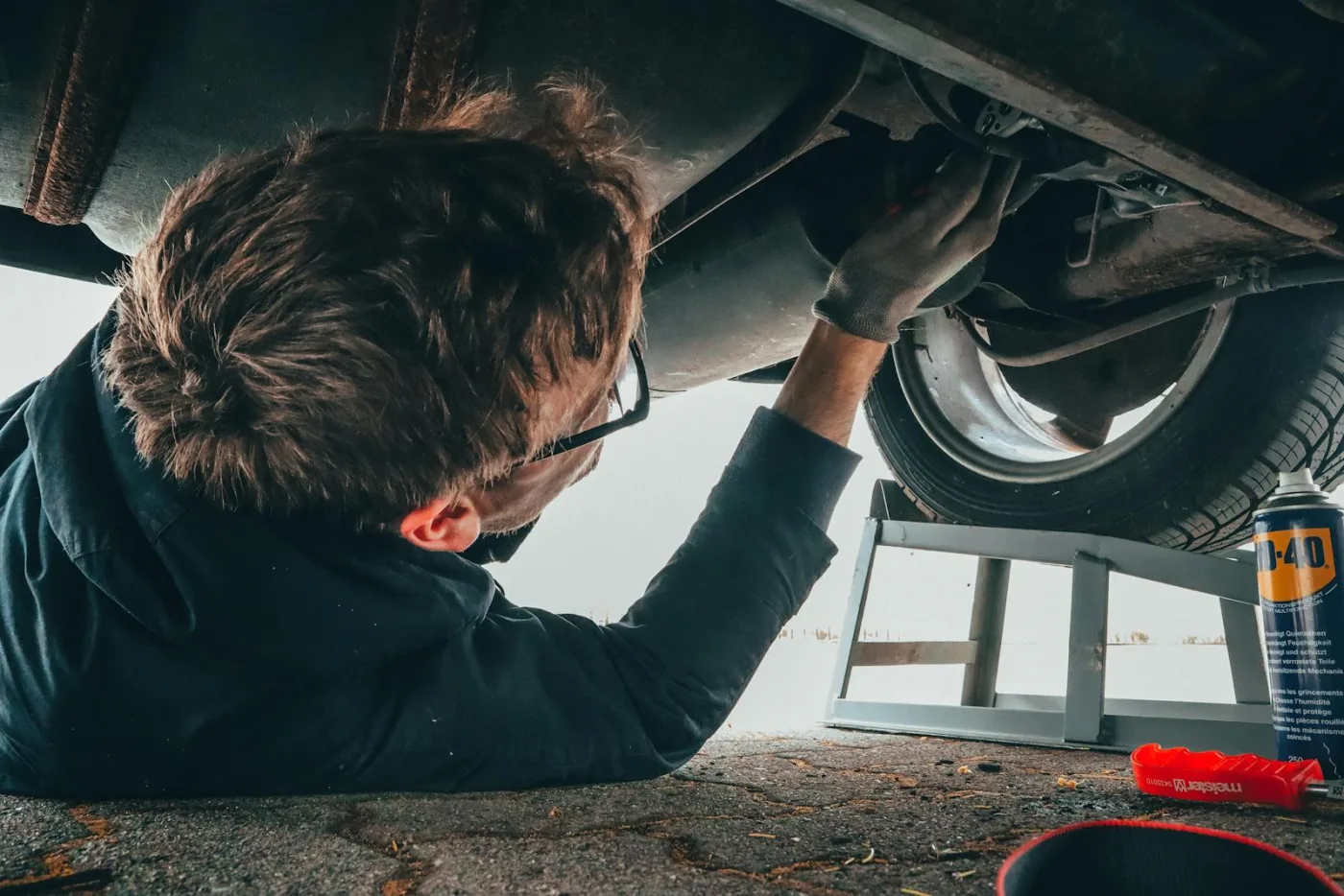 Mechanic working underneath a raised car